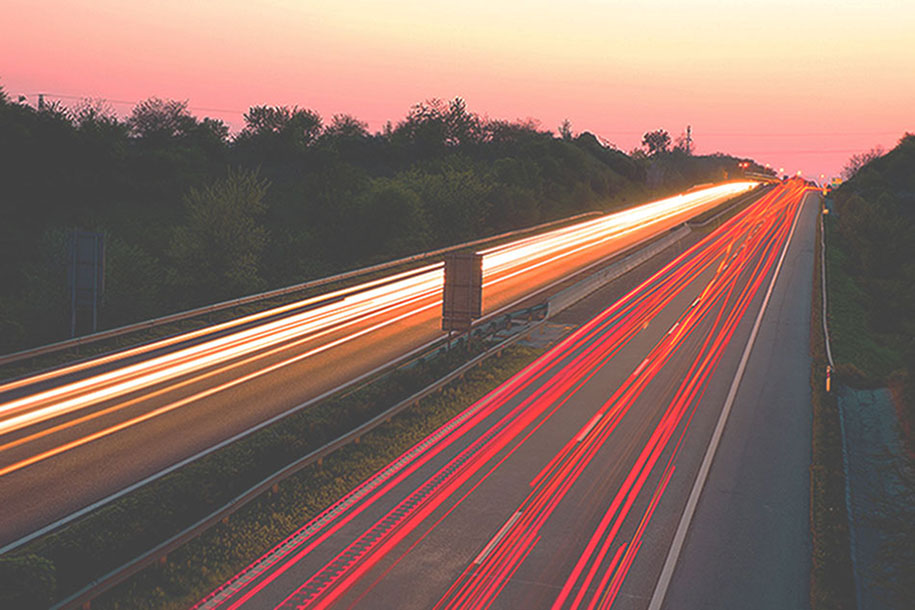 Cars in movement on a highway at sunset